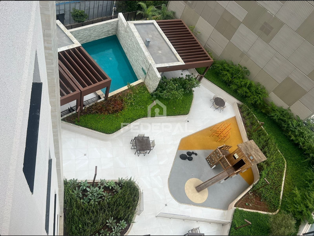 Área de lazer com piscina e playground vista aérea