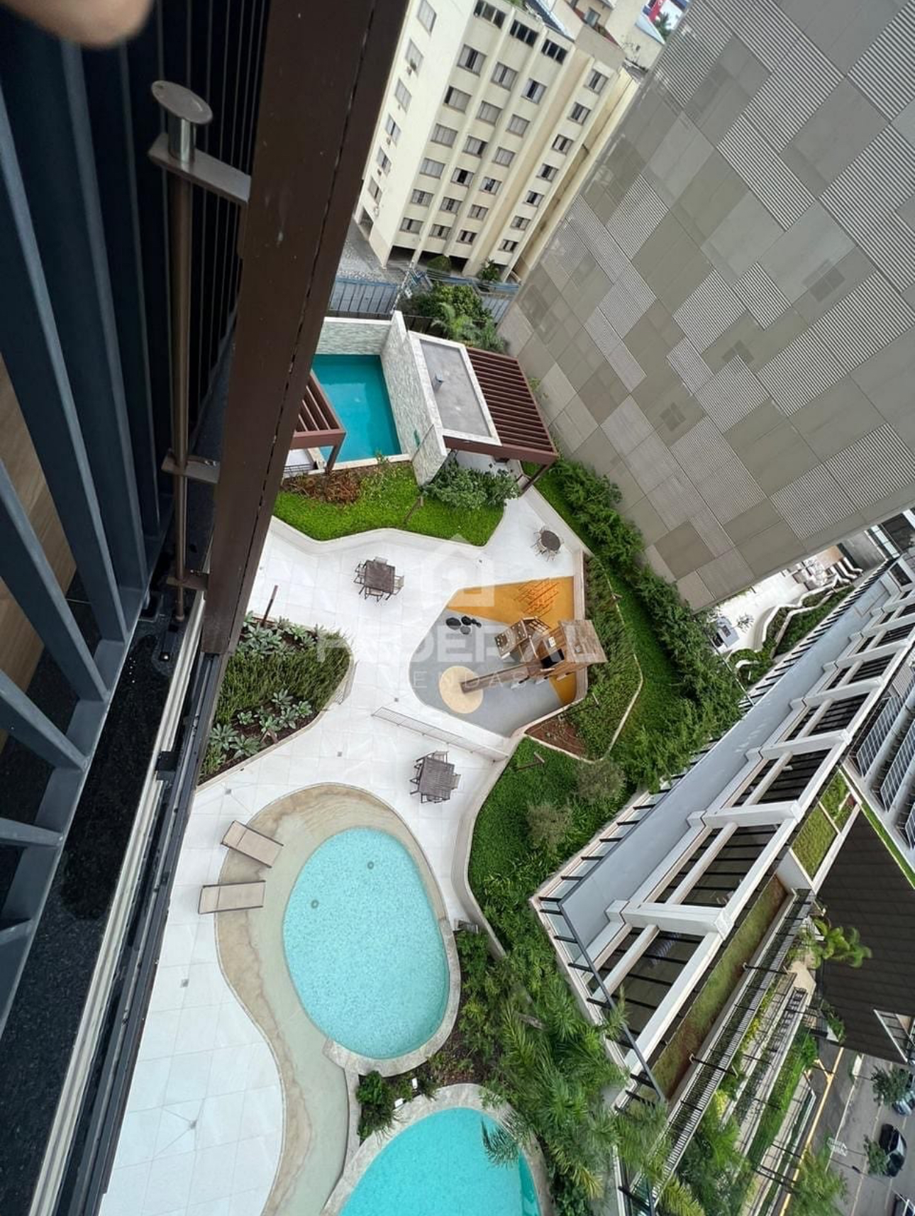 Vista aérea das piscinas e área verde do condomínio