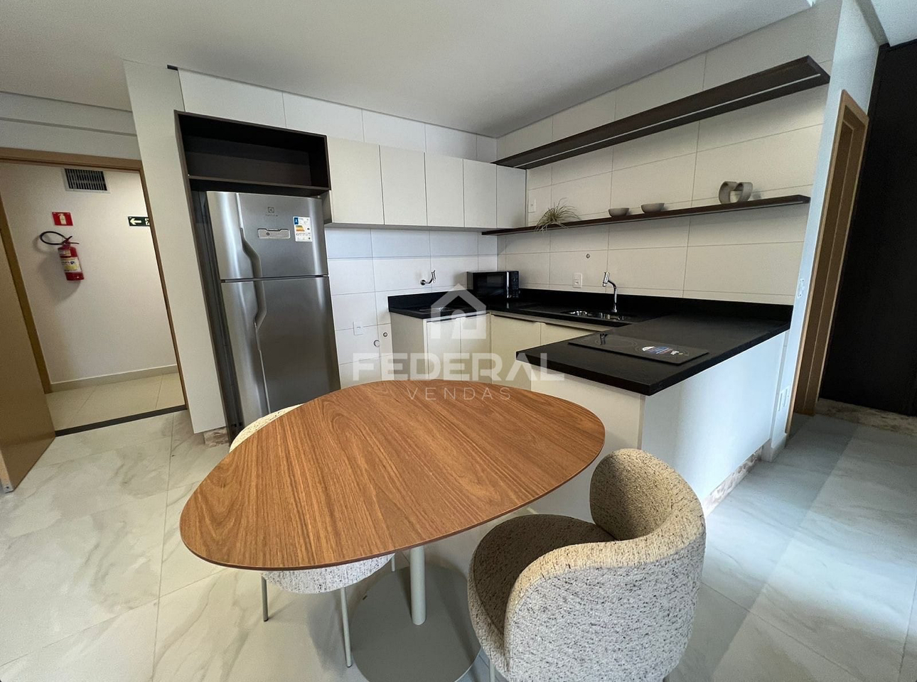 Cozinha americana mobiliada com bancada e geladeira